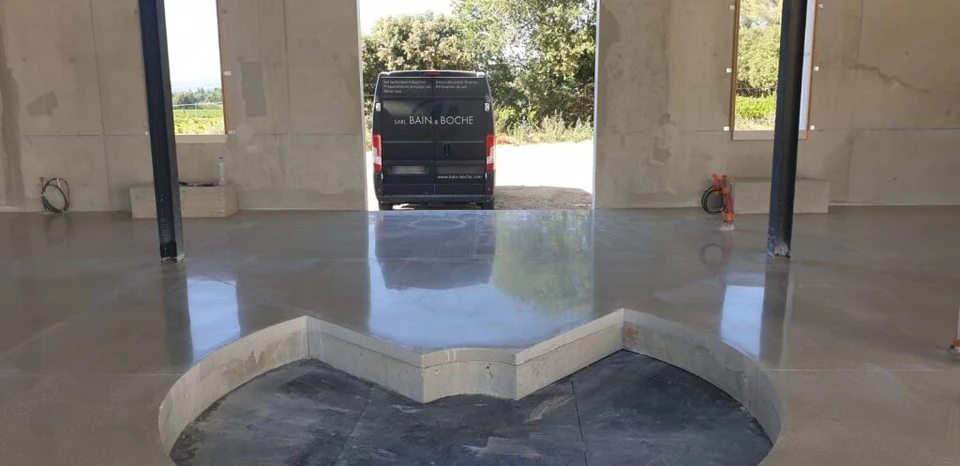 Ouvrier en tenue de travail effectuant des travaux de rénovation dans un local en béton brut