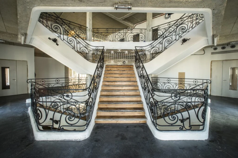 Vaste espace industriel vide, sol en béton ciré hautement poli à finition miroir, reflets lumineux intenses