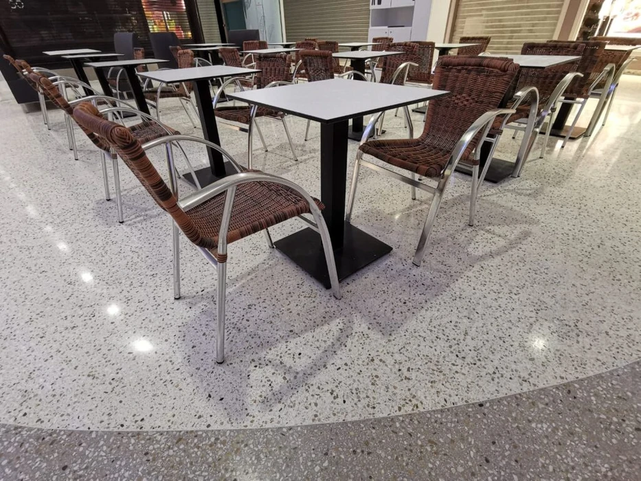 Vaste espace industriel vide, sol en béton ciré hautement poli à finition miroir, reflets lumineux intenses