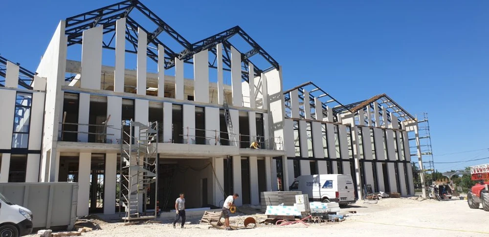 Vaste espace industriel vide, sol en béton ciré hautement poli à finition miroir, reflets lumineux intenses