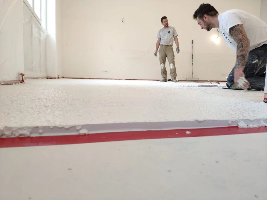 Vaste espace industriel vide, sol en béton ciré hautement poli à finition miroir, reflets lumineux intenses