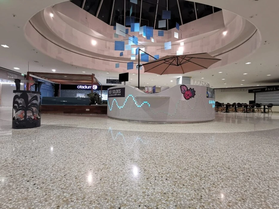 Vaste espace industriel vide, sol en béton ciré hautement poli à finition miroir, reflets lumineux intenses