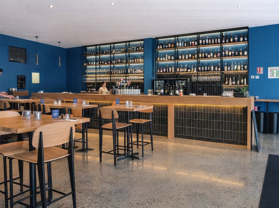 Vaste espace industriel vide, sol en béton ciré hautement poli à finition miroir, reflets lumineux intenses