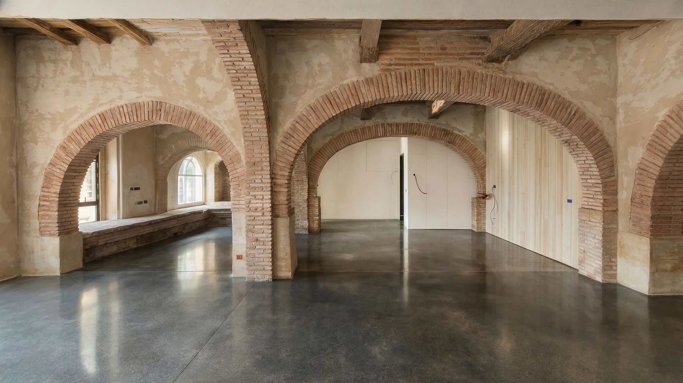 Photographie d'un sol intérieur en béton ciré de couleur décorative (teinte grise, beige ou autre finition mate), avec un rendu lisse et poli visible, photographié sous éclairage naturel montrant la texture et la qualité de la finition. La mise en perspective du sol doit permettre de voir sa surface polished et son intégration dans un espace intérieur moderne et épuré. Pas de personnes, pas de mobilier encombrant, focus sur la qualité et l'esthétique de la surface béton.