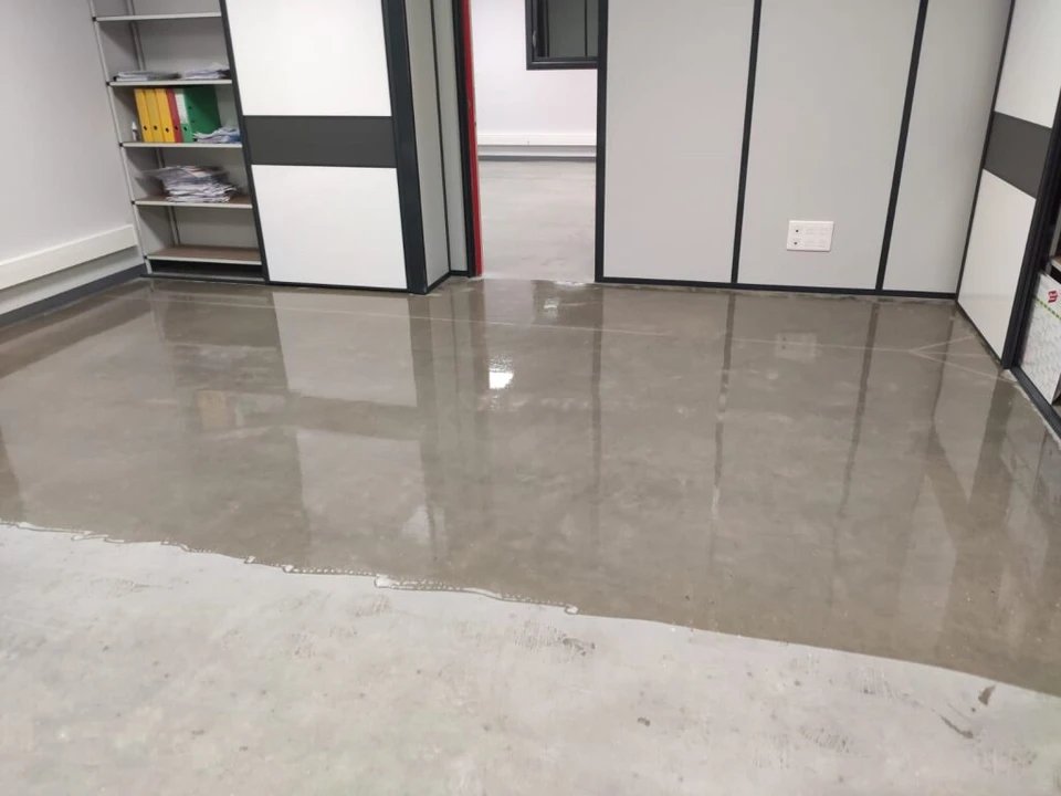 Terrasse extérieure d'une villa contemporaine avec une grande dalle de béton ciré poli à haute brillance, finition lisse