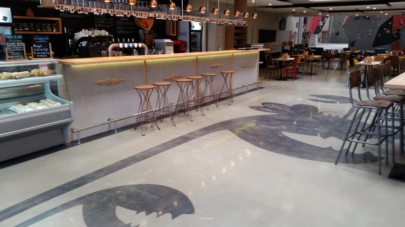 Sol en béton ciré poli haute brillance, teinte anthracite, dans une brasserie artisanale